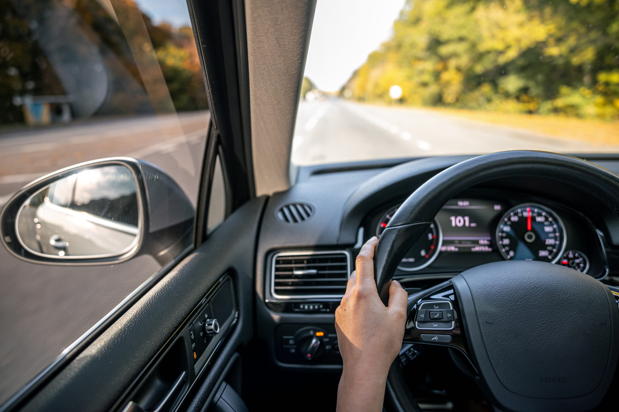 woman drivers hands steering wheel inside car